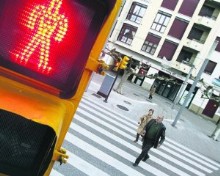 Imprudencia. Dos personas cruzan un paso de cebra, en la Acerona, con el semforo en rojo para peatones