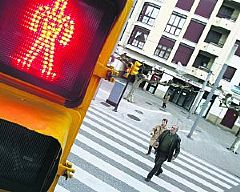 Imprudencia. Dos personas cruzan un paso de cebra, en la Acerona, con el semforo en rojo para peatones